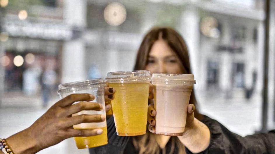Three customers raising Yummy Future cups to the camera